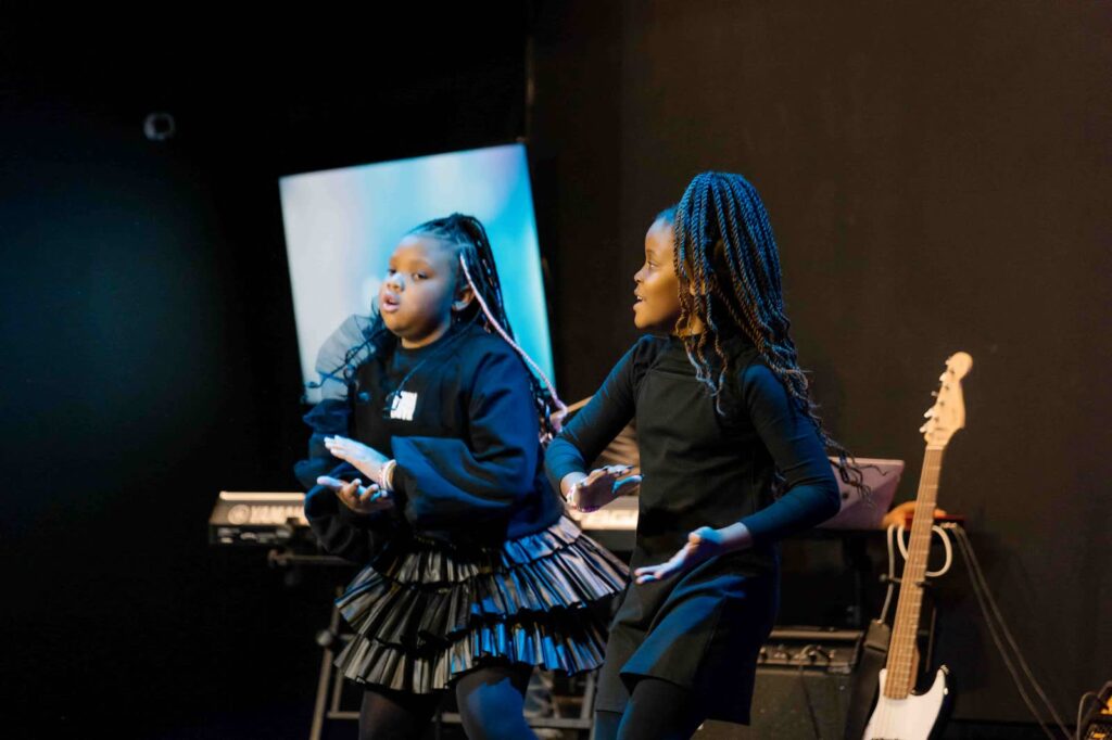 Two children singing and dancing on stage during a Glorious Kids service